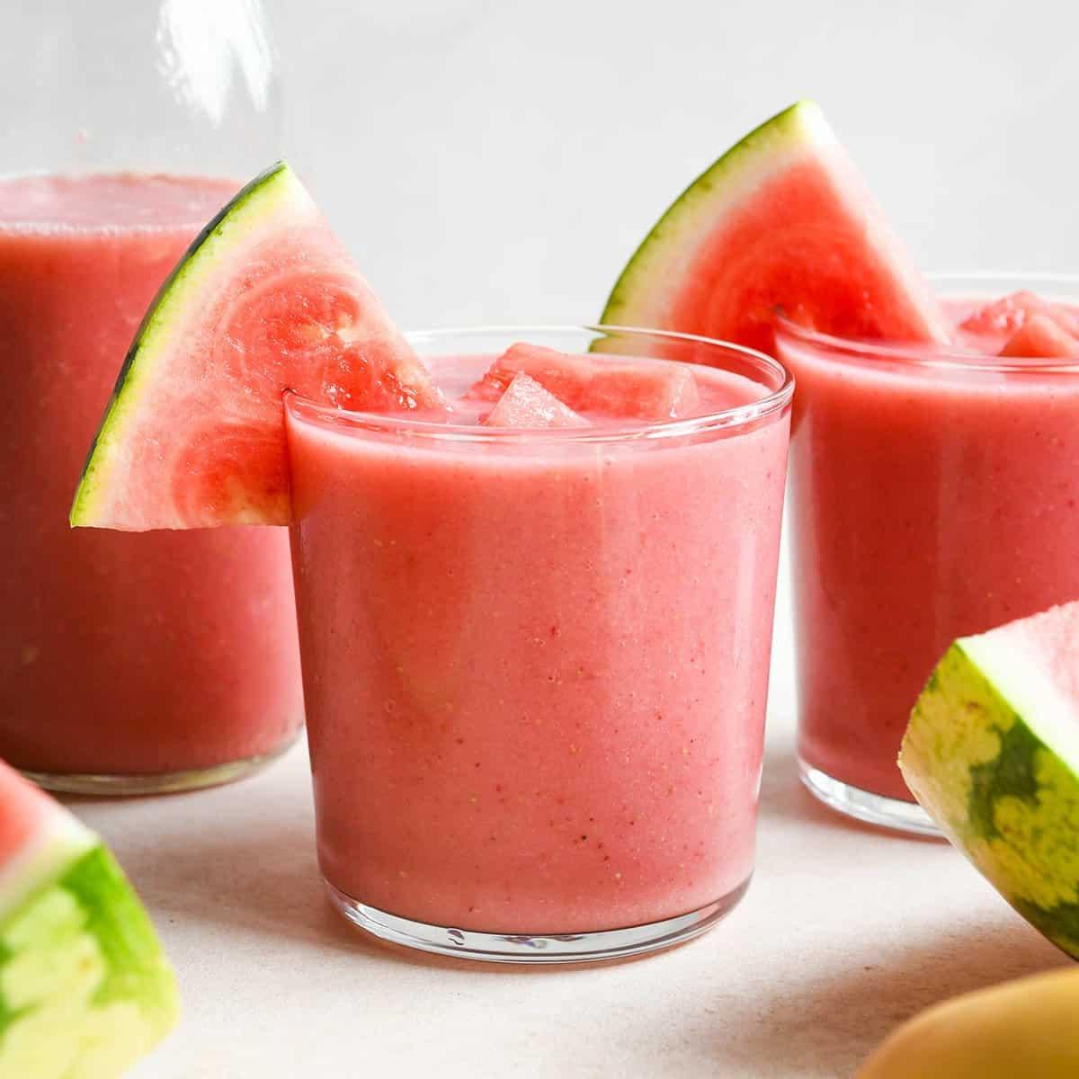 Τρία ποτήρια smoothie καρπούζι με φέτες καρπουζιού