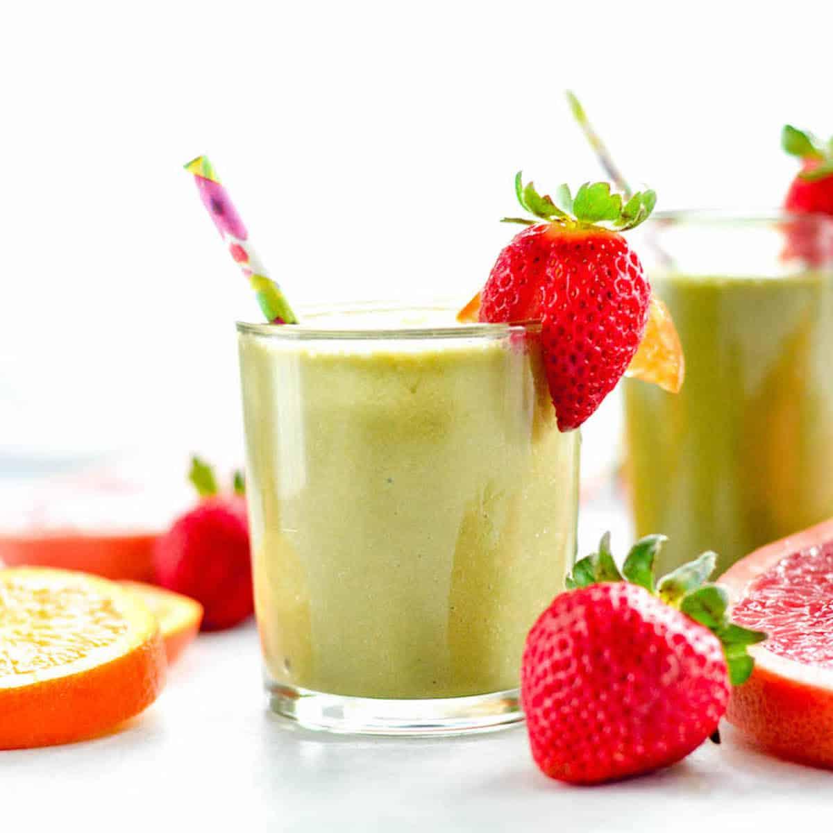 Μπροστινή όψη ενός ποτηριού Πράσινου Smoothie Εσπεριδοειδών με καλαμάκι και γαρνιτούρα φρούτων