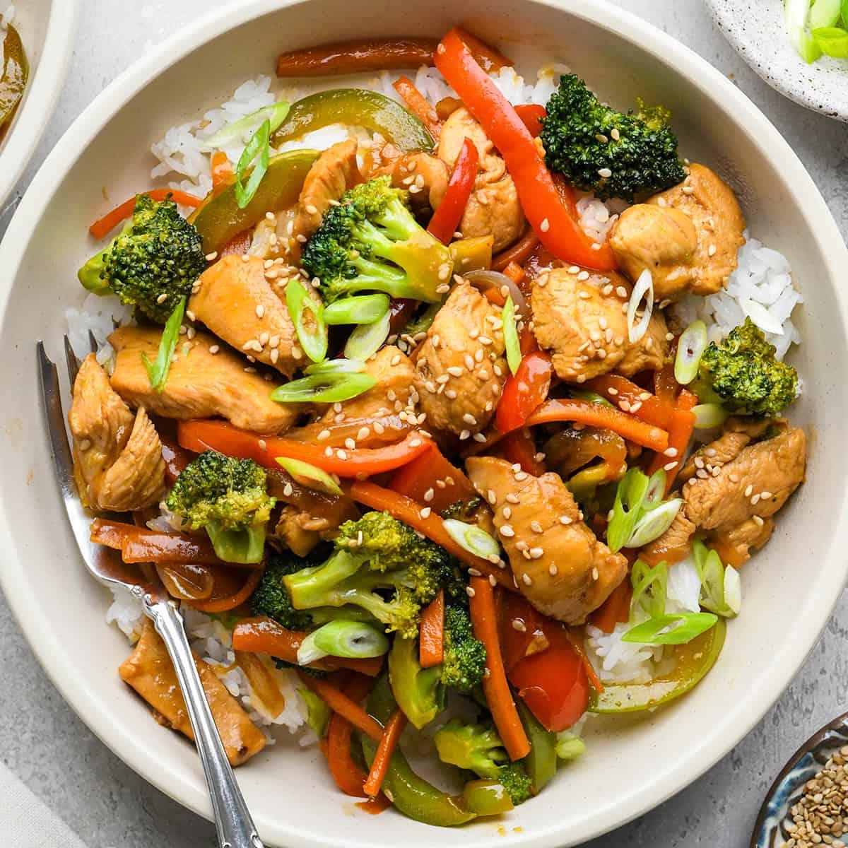 **Κοτόπουλο Σοτέ** 2 Κοτόπουλο Stir Fry με ρύζι σε μπολ με πιρούνι