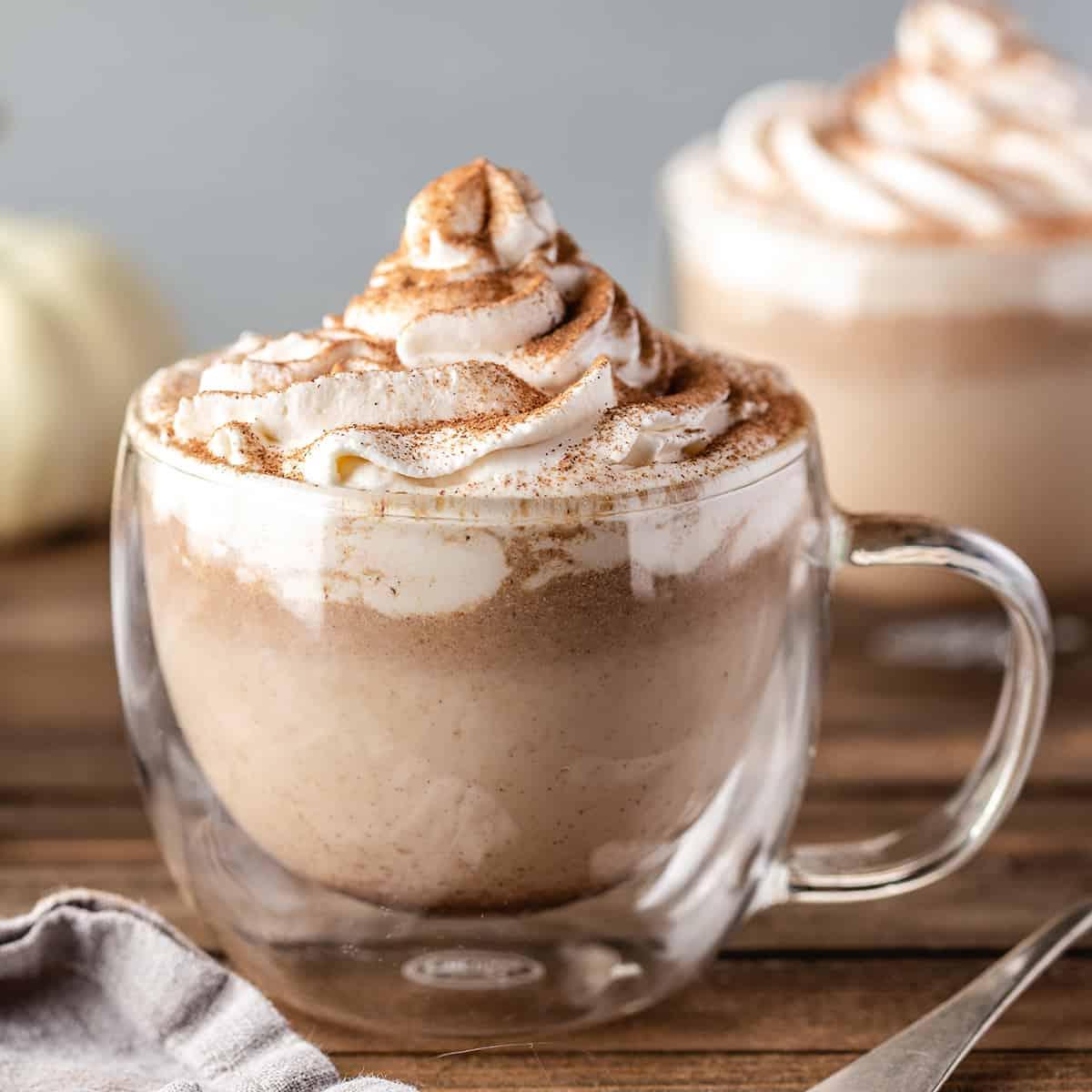 Κολοκυθένιο Λάτε Μπαχαρικών 2 Ένα Pumpkin Spice Latte σε μια γυάλινη κούπα με σαντιγύ και κανέλα