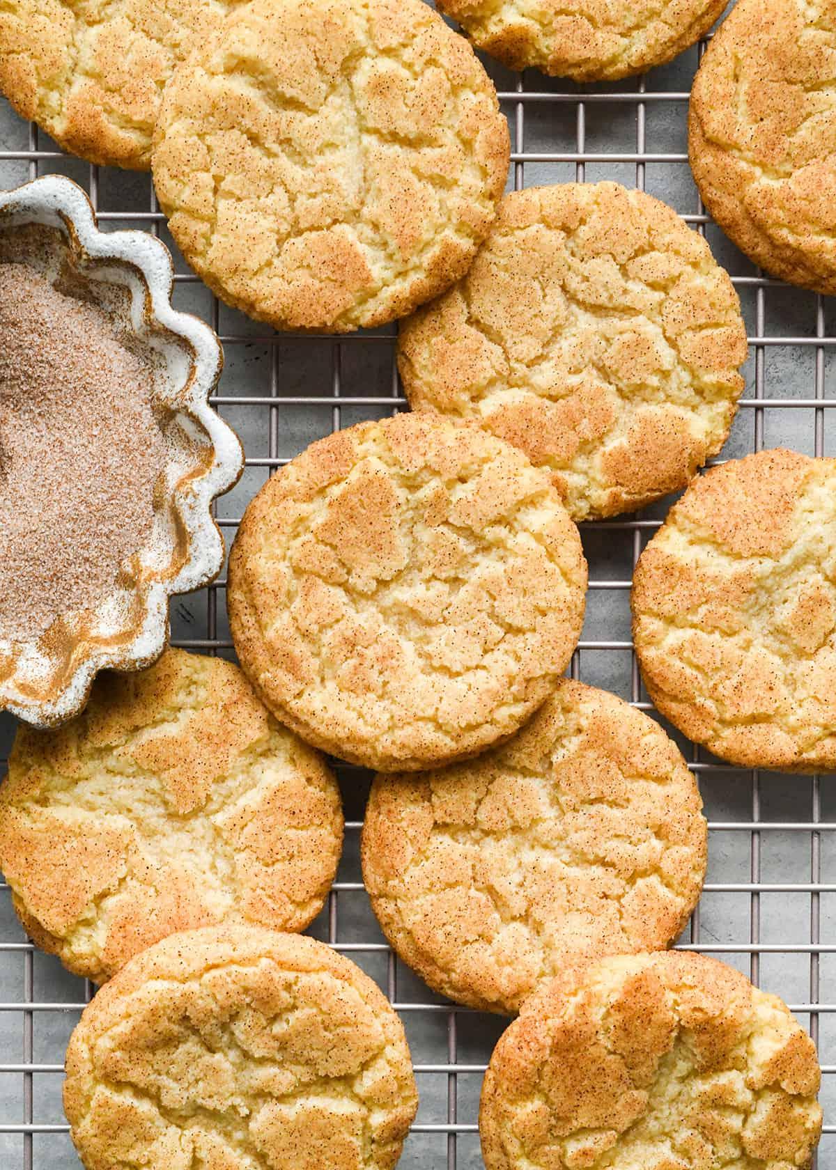 Η ΚΑΛΥΤΕΡΗ συνταγή για Snickerdoodle ποτέ! Αυτά τα μπισκότα snickerdoodle έχουν τραγανές άκρες, μαστιχωτό κέντρο και πλούσια γεύση κανέλας. Είναι εύκολο να φτιαχτούν χωρίς ψύξη ή περίεργα υλικά! Μια κλασική χριστουγεννιάτικη συνταγή που πέρασε από τη γιαγιά μου και ψήνω από τότε που ήμικρό κορίτσι!#snickerdoodle #snickerdoodles #snickerdoodlecookies #christmascookies #bestsnickerdoodlerecipe #recipe #cookies 10 snickerdoodles σε σχάρα ψύξης