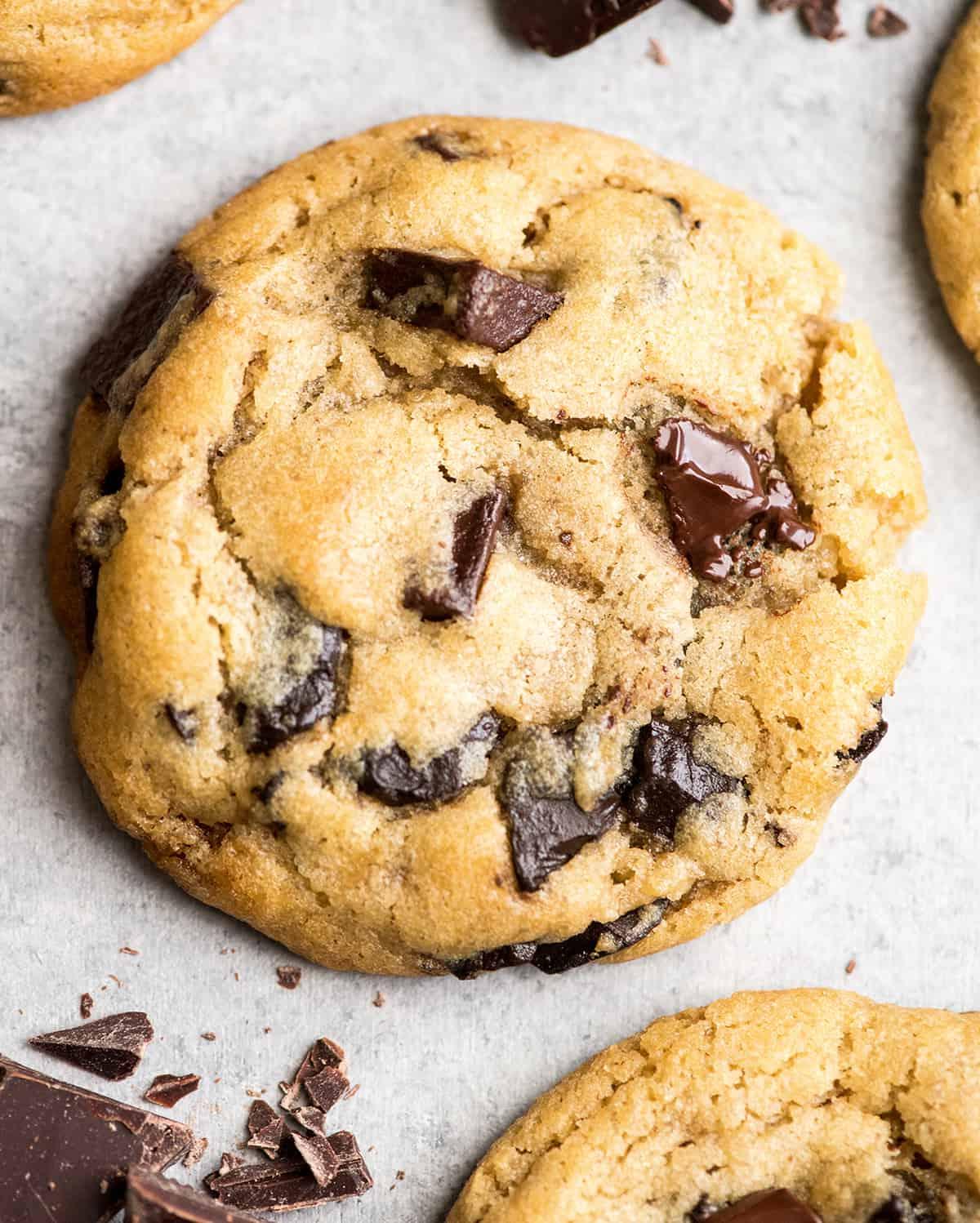 Αυτή είναι η καλύτερη συνταγή για chocolate chip cookies που έχετε δοκιμάσει ποτέ. Χωρίς περίεργα υλικά, χωρίς χρόνο ψύξης, κ.λπ. Απλά ένα απλό, εύκολο στην παρασκευή του, απίστευτα νόστιμο, ζυμαρένιο αλλά πλήρως ψημένο, cookie με κομματάκια σοκολάτας που βγαίνει τέλειο κάθε φορά! #cookies #chocolatechipcookies #baking #recipe #chocolate Κοντινή προβολή από πάνω ενός chocolate chip cookie