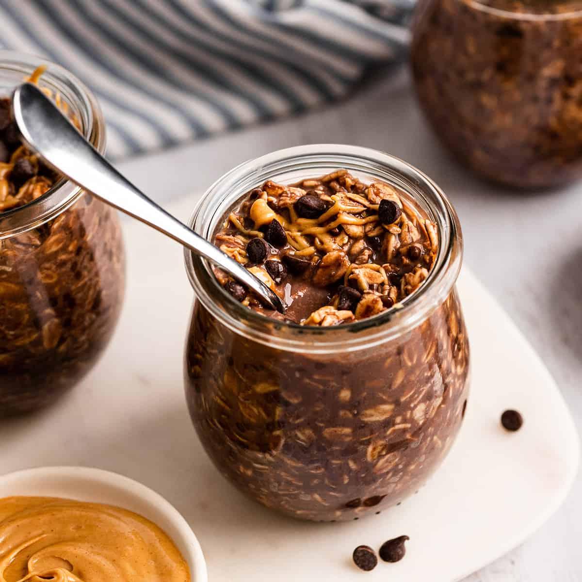 a jar of Chocolate Peanut Butter Overnight Oats with a spoon in it