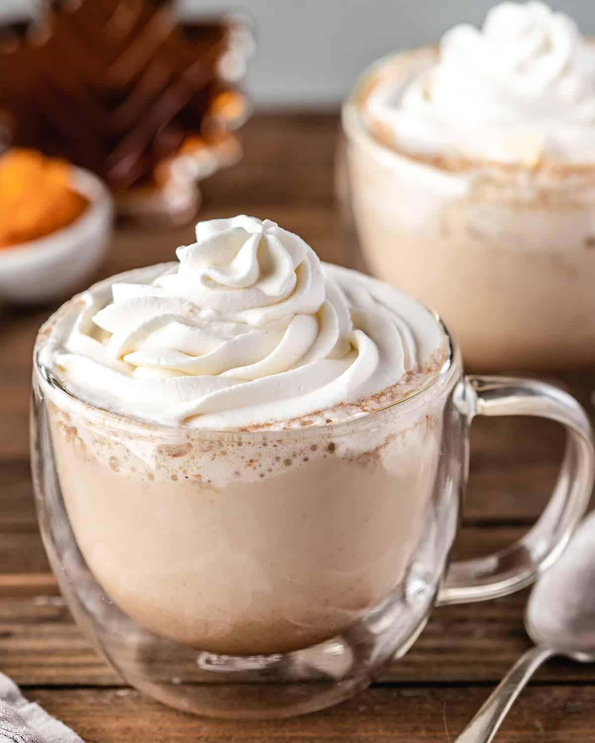 Κολοκυθένιο Λάτε Μπαχαρικών 3 Pumpkin Spice Latte σε μια γυάλινη κούπα με σαντιγύ