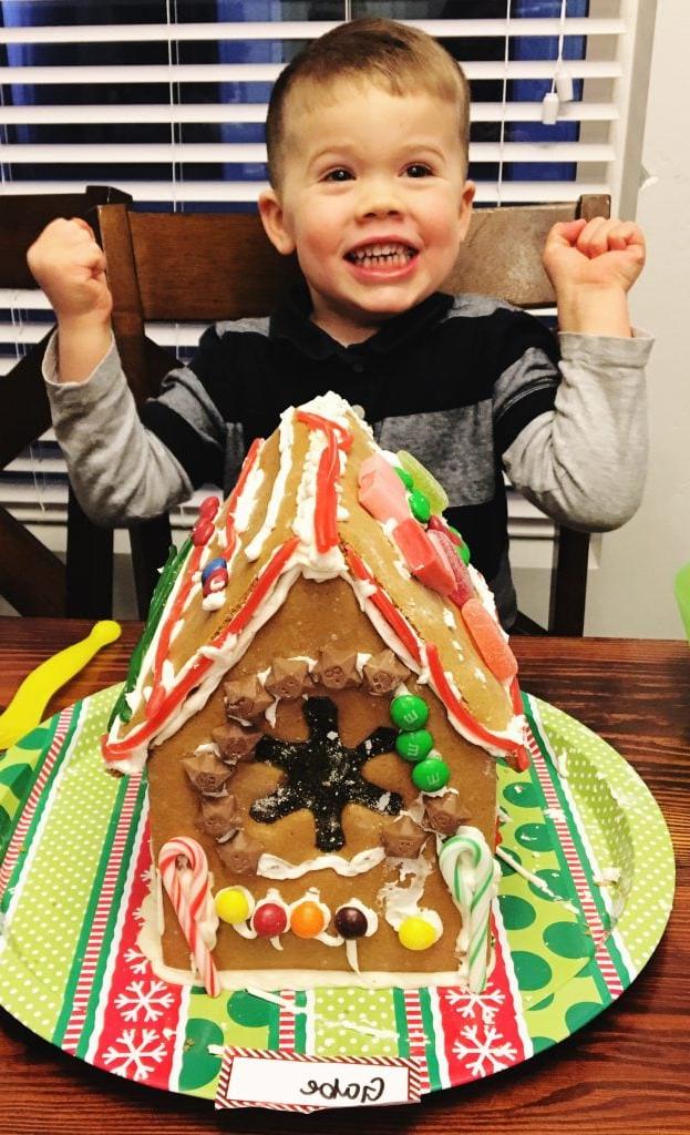 Παιδί ετοιμάζεται να διακοσμήσει σπιτάκι gingerbread