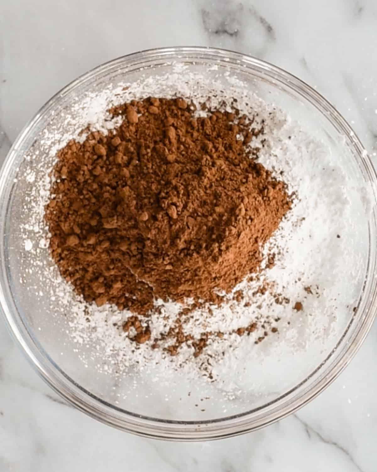 Πώς να φτιάξετε σοκολατένιο Puppy Chow - κακάο σε σκόνη και ζάχαρη άχνη σε μπολ πριν την ανάμειξη
