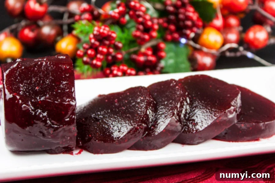 Easy Homemade Cranberry Sauce Your Way 9 Cranberry sauce sliced on a white tray with berries in the background.