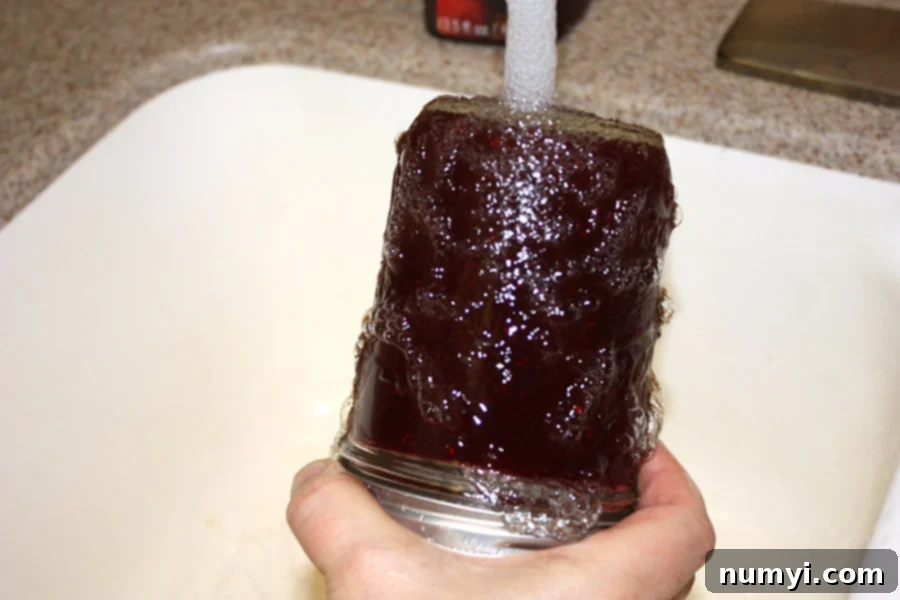 Easy Homemade Cranberry Sauce Your Way 5 Mason jar upside down under running water.
