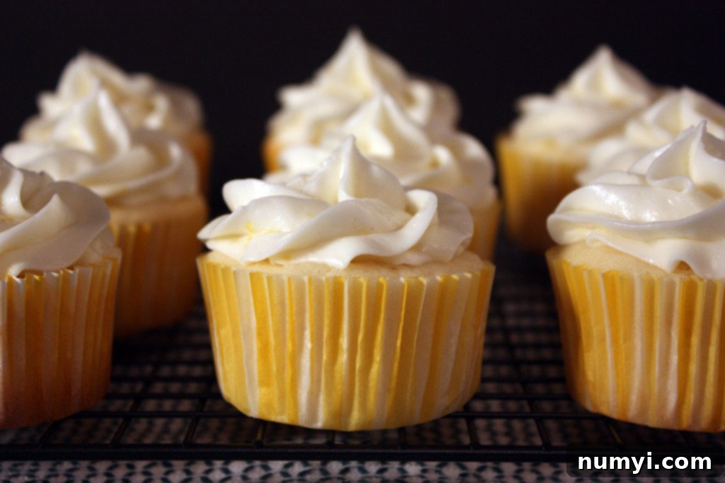 Lemon cupcakes on a wire rack cooling, showcasing their golden-brown tops and delicate texture.