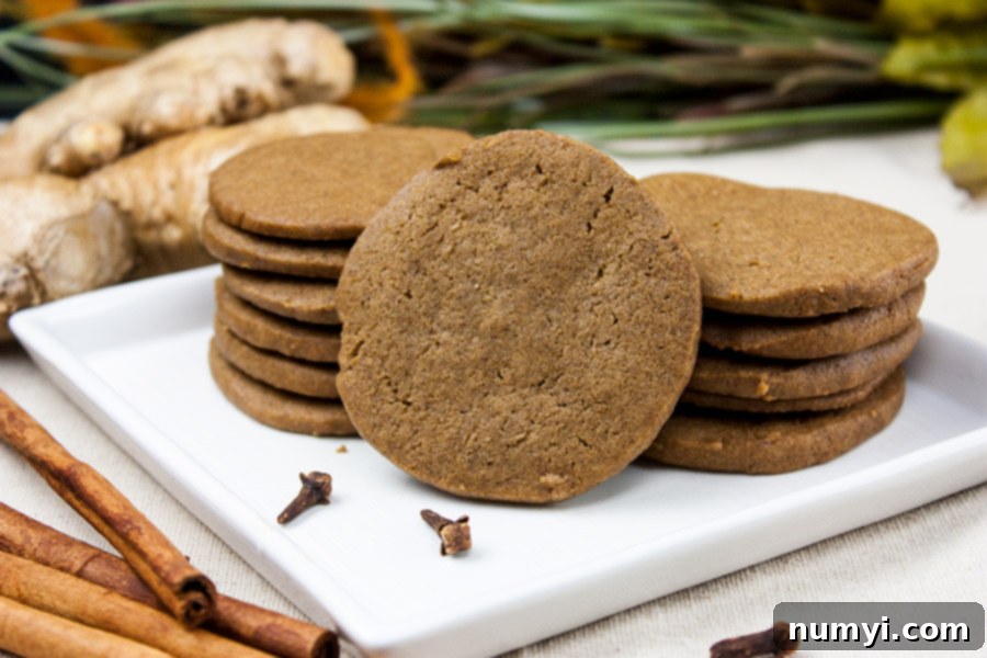 Crispy Gingersnap Cookies stacked neatly on a white plate, ready to be enjoyed.