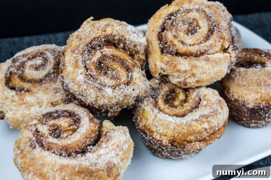 Sticky Buns 8 A stack of perfectly baked, sugar-dusted morning buns on a white plate, showcasing their inviting golden color.