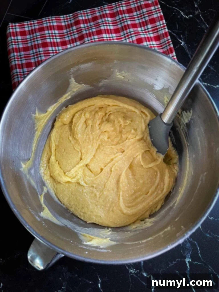 Spiced Eggnog Bundt with Creamy Glaze 4 Rich Eggnog Bundt Cake batter, smooth and creamy, in a metal stand mixer bowl, ready for baking.