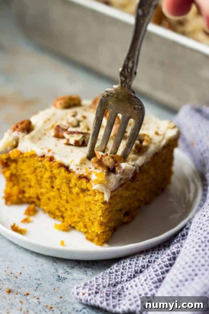 This Easy Pumpkin Cake with Cream Cheese Frosting is a lot easier than a pumpkin cake roll but tastes just like it! It's moist, full of pumpkin spice, topped with a dreamy cream cheese frosting and perfect for fall!
