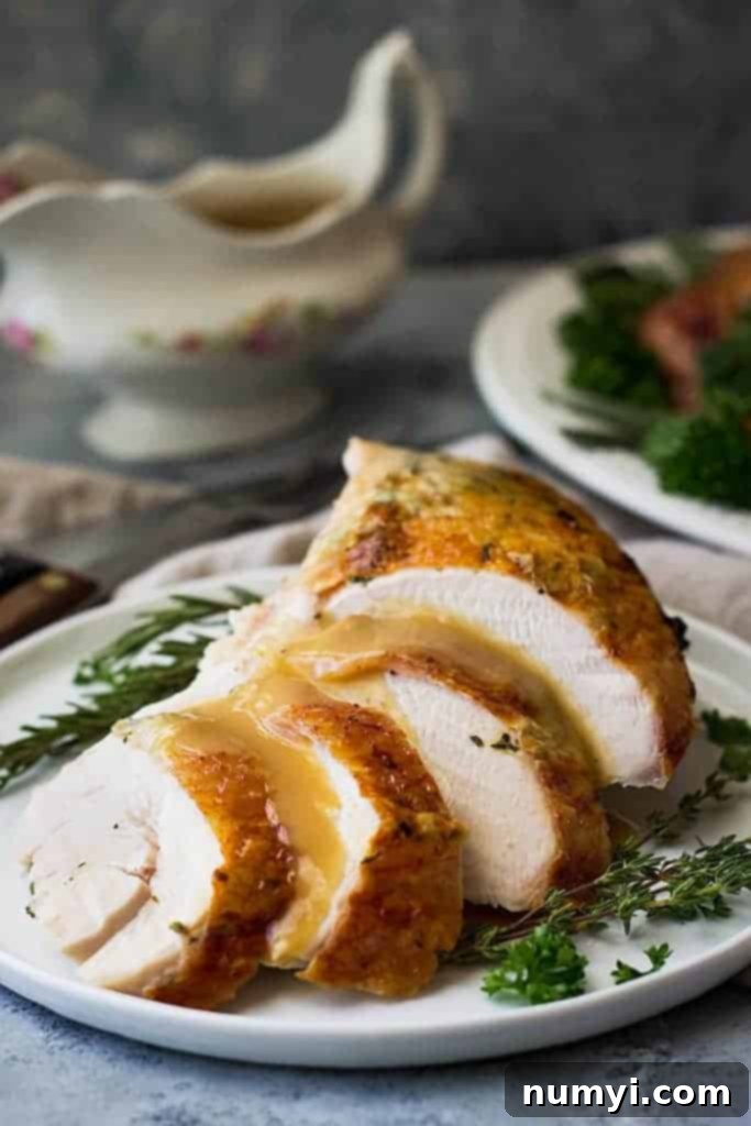 Close-up of a perfectly roasted spatchcocked turkey, golden brown and glistening, on a white serving dish.