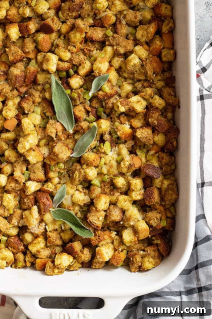 Top down view of freshly baked homemade herb stuffing garnished with fresh sage leaves.