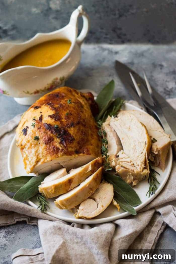 Full slow cooker turkey breast, beautifully golden, alongside carved slices on a white serving platter with carving utensils.