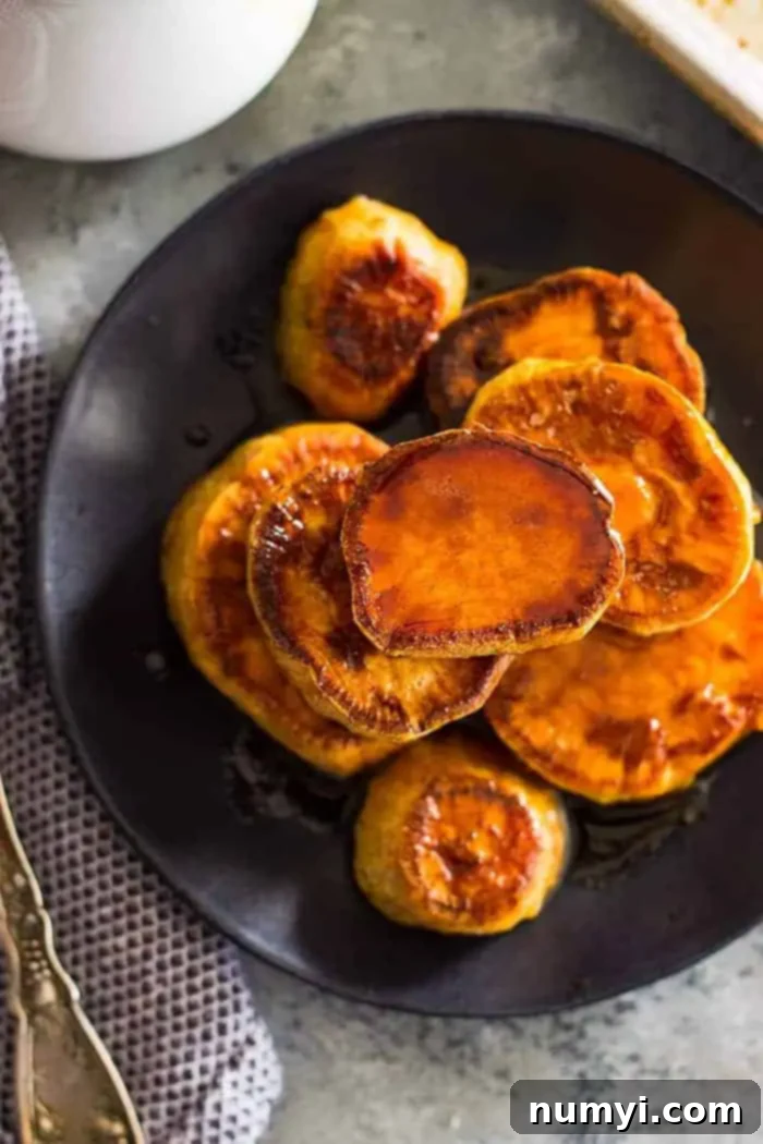 overhead: a stack of cinnamon sweet potatoes on a black plate