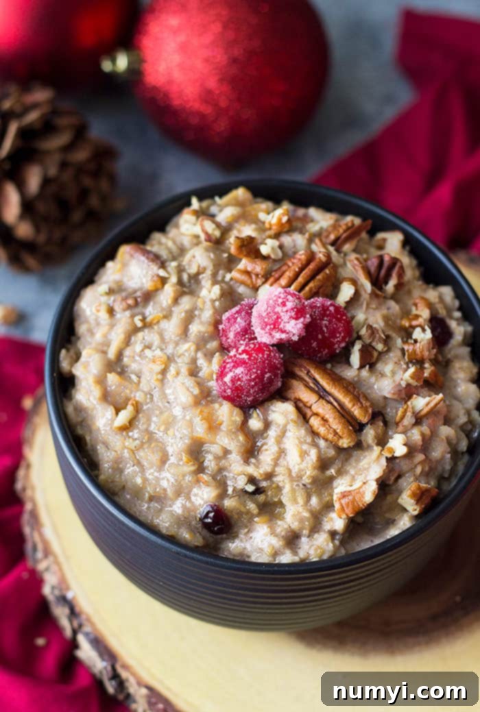 A beautifully layered Mason Jar Gift Fruit and Nut Oatmeal, perfect for a healthy Christmas morning breakfast, topped with fresh fruit and Greek yogurt.