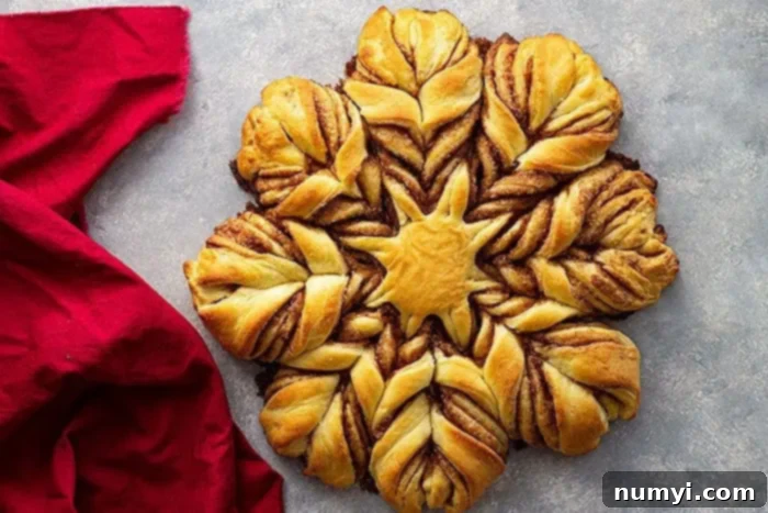 The finished Brioche Cinnamon Snowflake Bread, golden brown and perfectly baked, viewed from above to highlight its intricate star pattern.