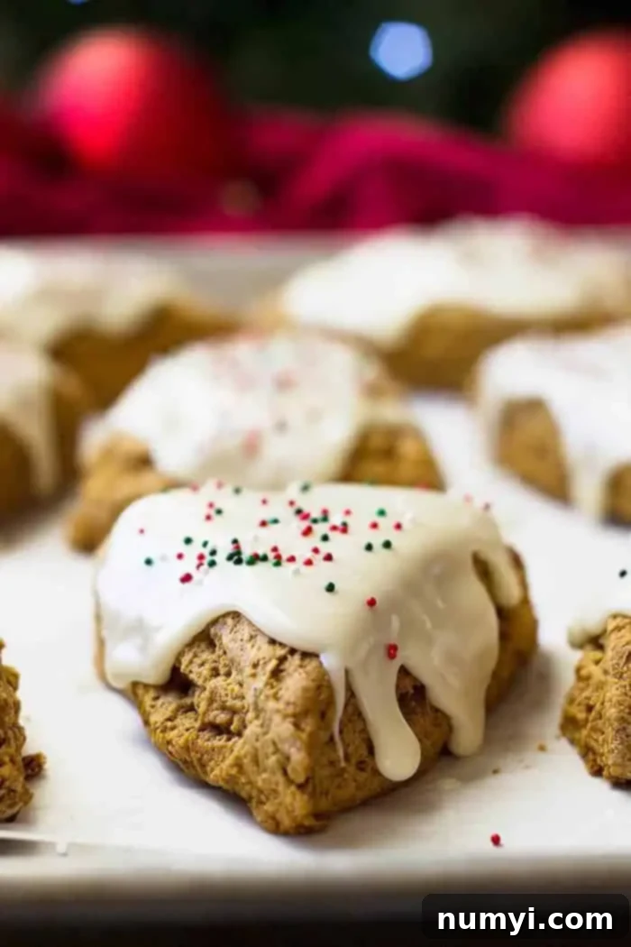 Warm Gingerbread Scones with Tangy Cream Cheese Frosting 4 Closeup shot of a gingerbread scone with a generous swirl of cream cheese frosting and colorful sprinkles.
