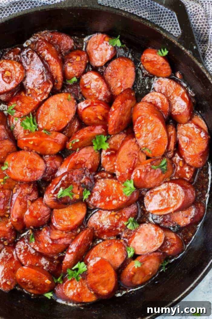 Smoked Sausage Skillet Delight 2 Delicious honey garlic smoked sausage appetizer in a rustic skillet, glistening with a sweet and savory glaze.