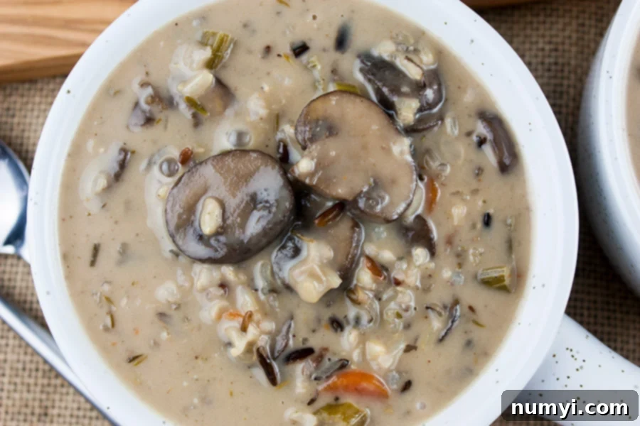 Wild rice and mushroom soup served in a white ceramic crock.