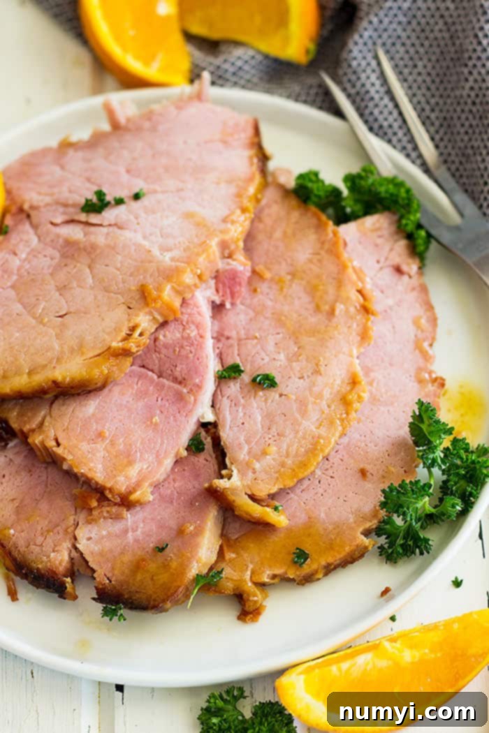 Irresistible Honey Mustard Ham Glaze 5 Close up picture of sliced Slow Cooker Honey Mustard Glazed ham on a plate, showing its juicy texture and rich glaze.
