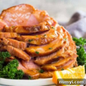 Irresistible Honey Mustard Ham Glaze 6 Slow cooker honey mustard glazed ham sliced and stacked tall on a plate. Garnished with chopped parsley.