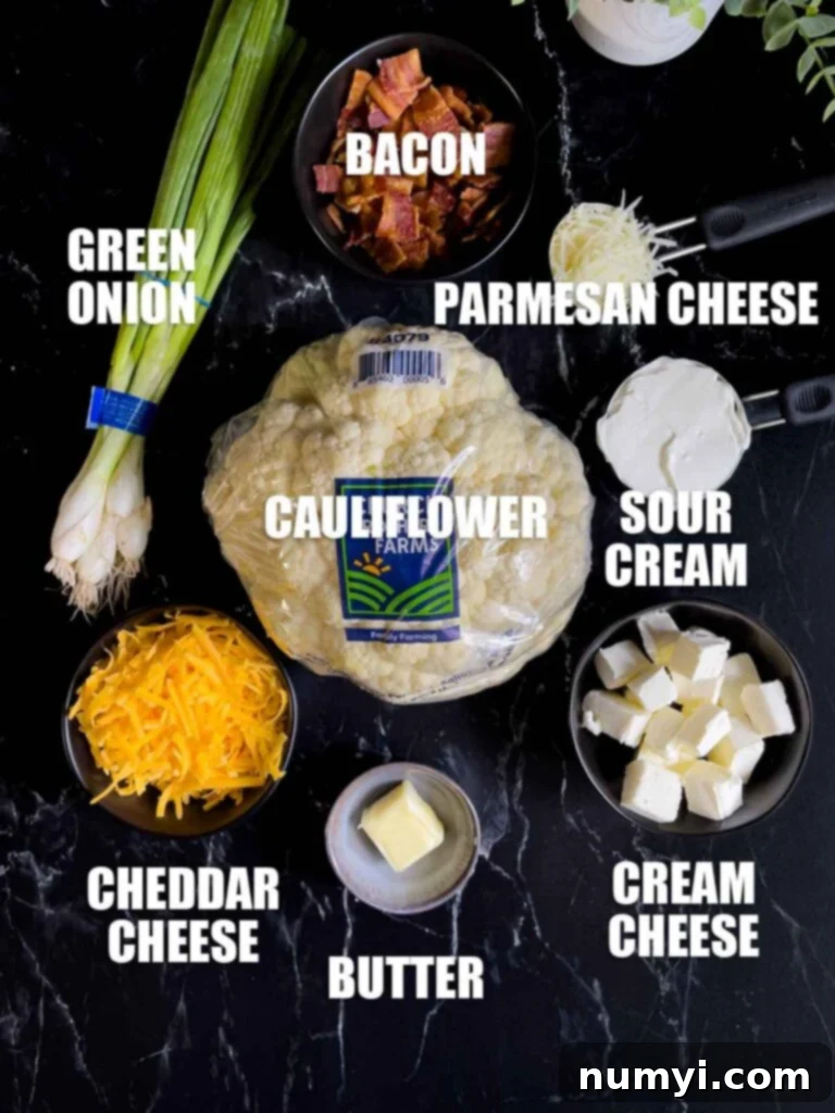 Ingredients for Loaded Cauliflower Mash Casserole laid out on a dark kitchen surface.