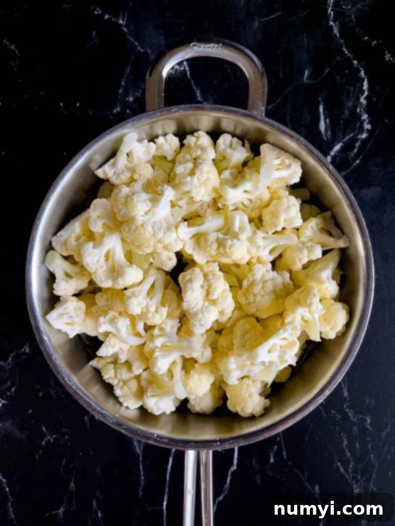 Cut cauliflower in a large pot with a steaming basket.