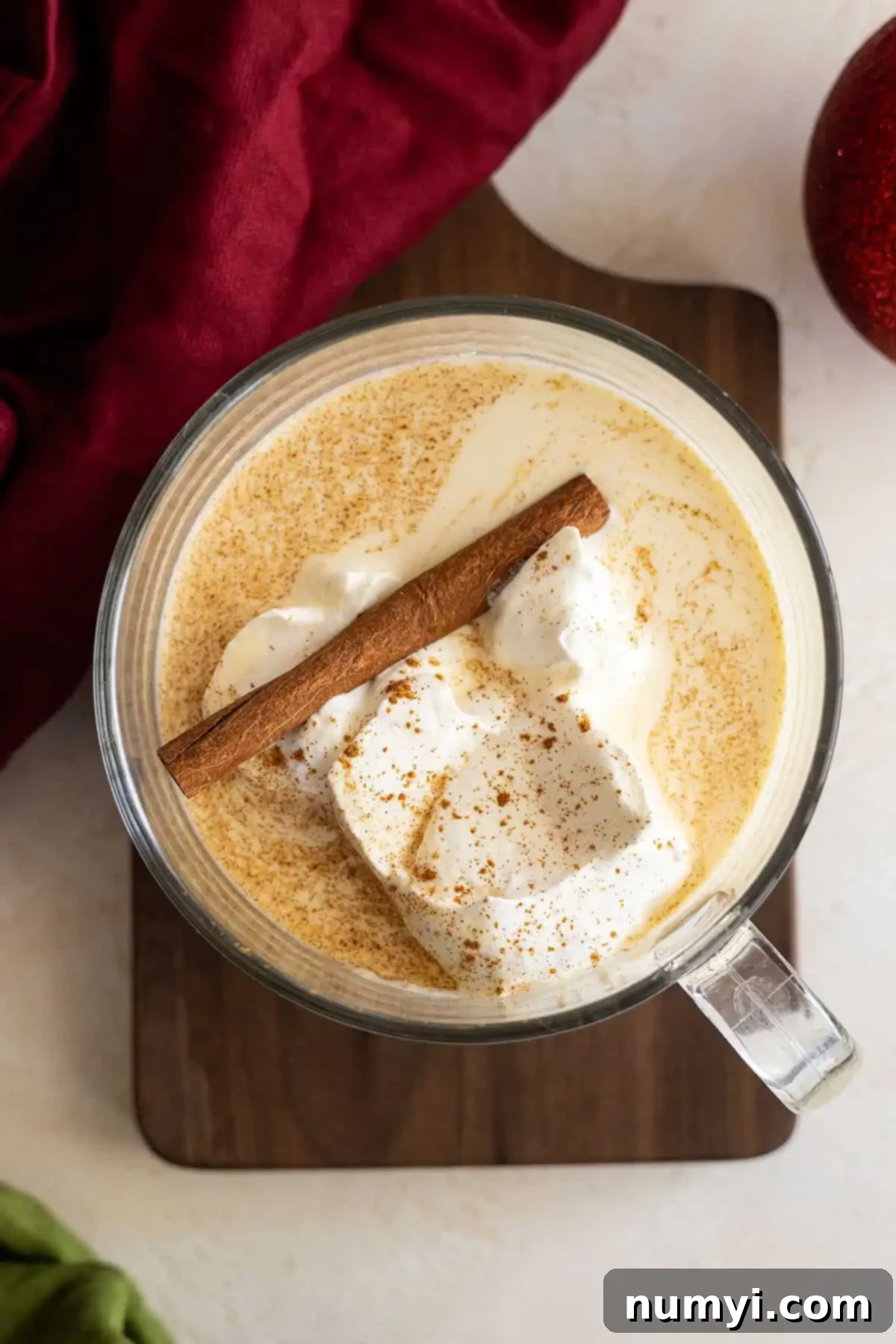 Creamy Homemade Eggnog 2 Overhead view of eggnog in a large cup topped with whipped cream and a cinnamon stick.