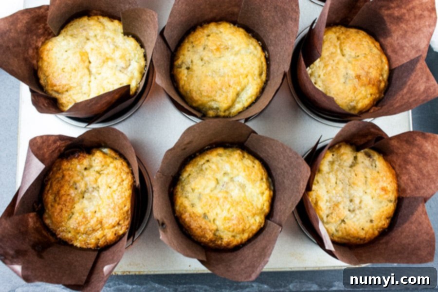 A tray of Best Ever Banana Muffins baked in brown liners, showcasing their uniformity and golden tops.