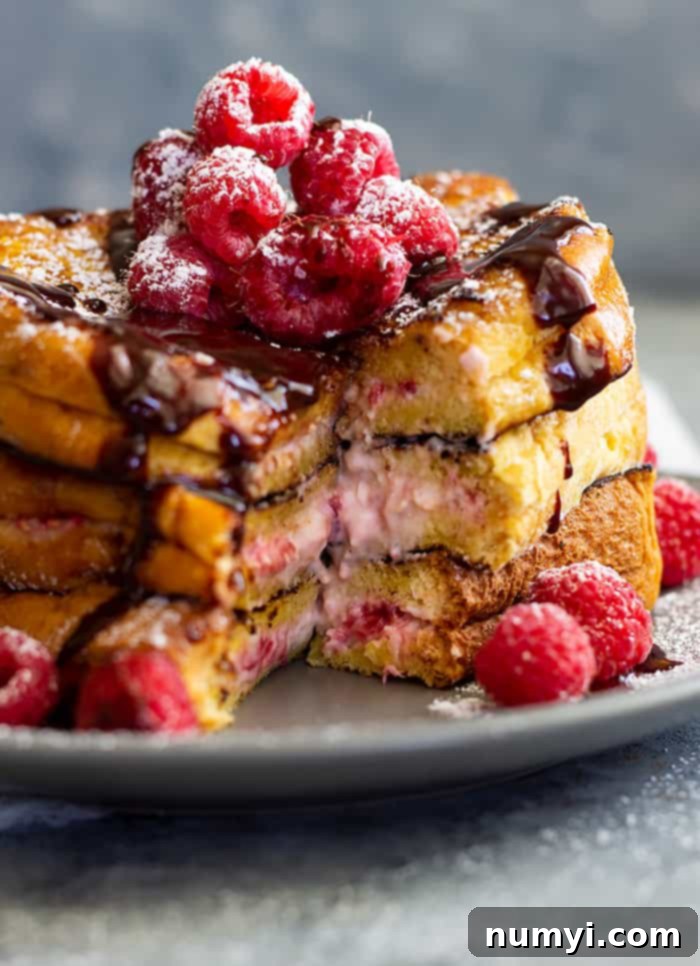 Raspberry Cheesecake Stuffed French Toast - a rich and decadent breakfast for any special occasion! Fresh raspberries mixed with cream cheese stuffed between rich brioche bread makes a special treat!