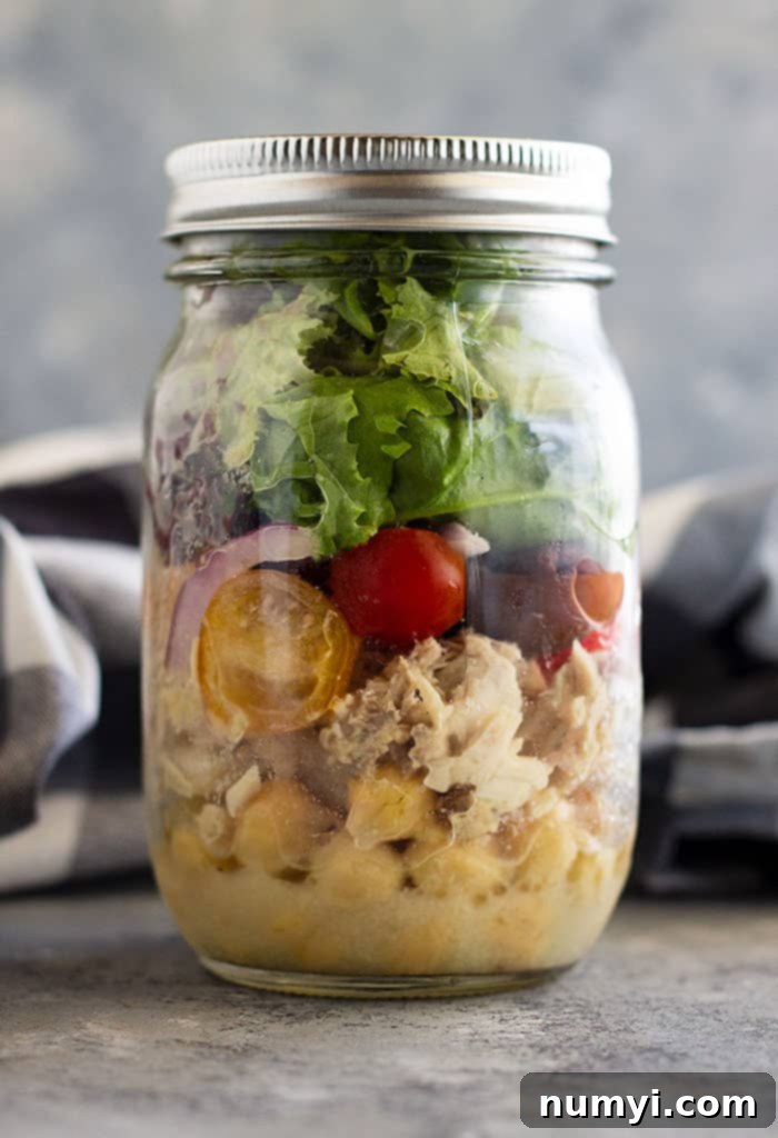 Overhead shot of a beautifully arranged Quick Tuscan Tuna Salad, showcasing its fresh ingredients like chickpeas, tuna, tomatoes, and olives, making a perfect light summer meal.