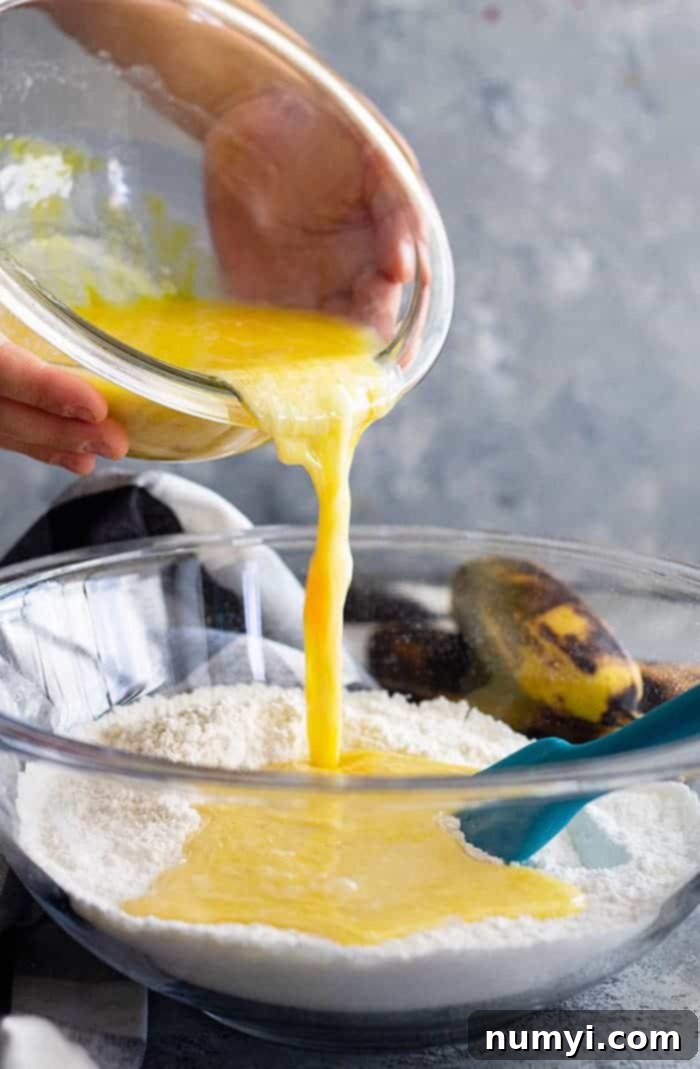 This Easy Banana Bread is perfectly moist, not gummy, and will become a family favorite I GUARANTEE it! It's perfect as is or throw in some chocolate chips or nuts to make it your own! #easyrecipe #bananabread #quickbread