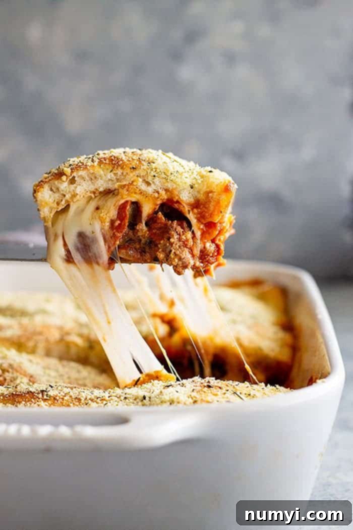 This Upside Down Pizza Casserole is filled with 3 meats, vegetables, and gooey cheese! Top with homemade or store bought pizza dough or even biscuits for the ultimate weeknight meal. #easyrecipe #casserole #pizza