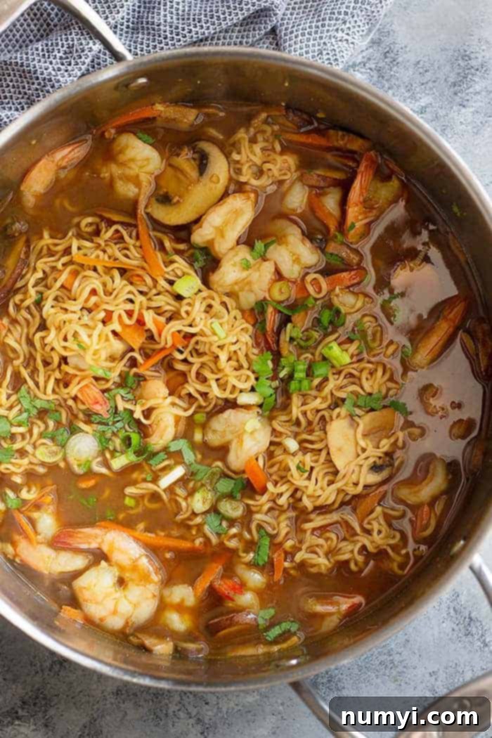 top down view of seafood ramen in a pot with ladle
