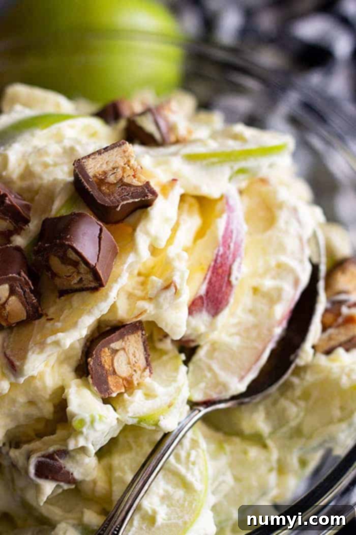 A close up of Snickers apple salad with a spoon.