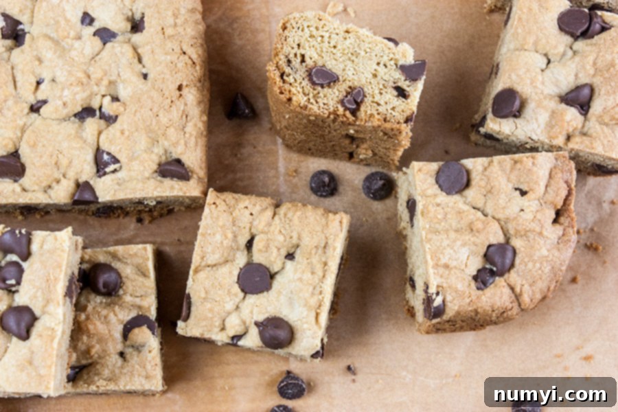 Freshly cut chocolate chip cookie bars arranged on a wooden board, ready for serving.