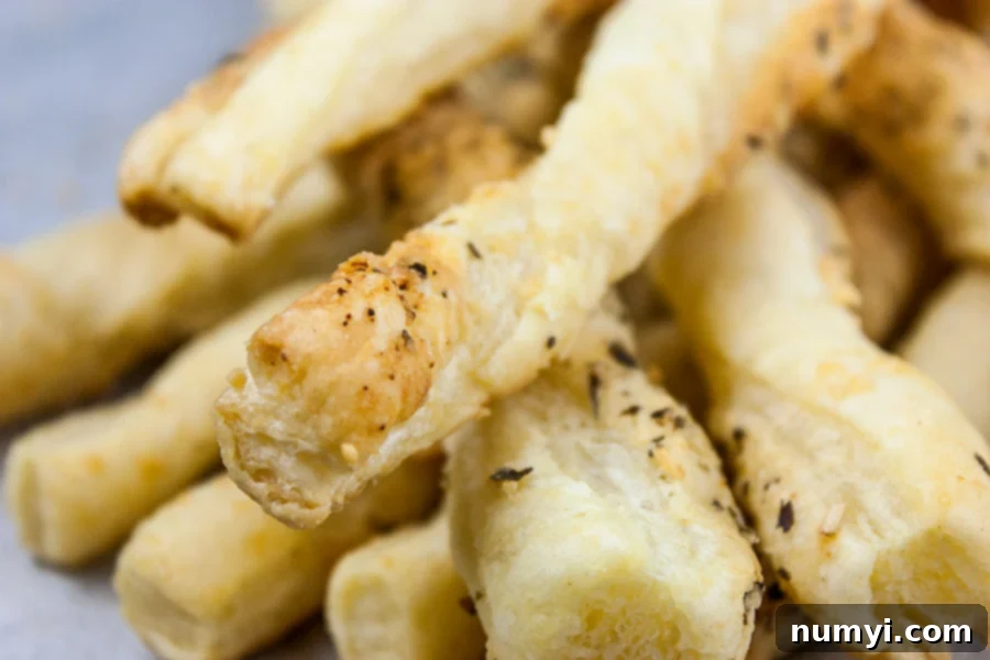 Stacked crispy Puff Pastry Parmesan Cheese Straws, ready to serve.