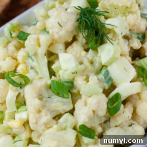 Keto-Friendly Cauliflower Mock Potato Salad Recipe Cauliflower Mock Potato Salad in a white serving dish, garnished with fresh dill.