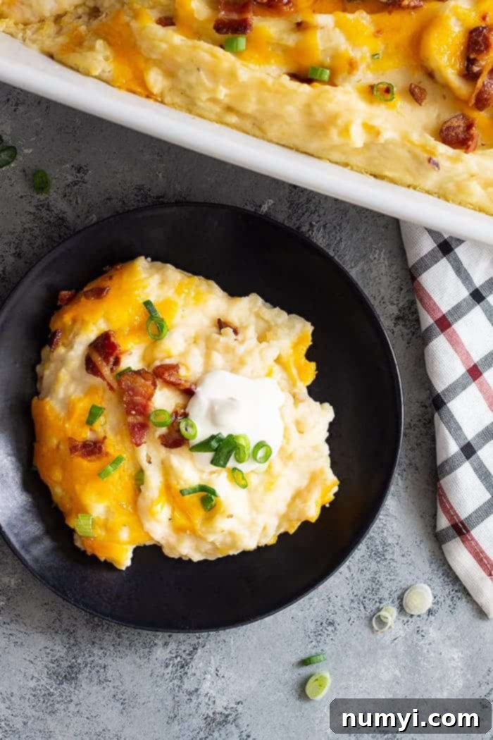 overhead: a serving of casserole with mashed potatoes with bacon and sour cream on top, ready for a fork