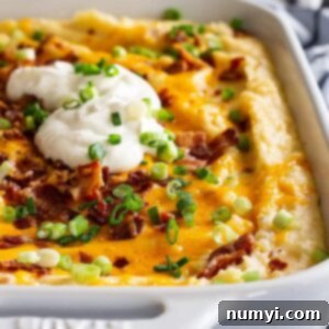 This Loaded Mashed Potato Casserole is the perfect make ahead side dish! It's filled with bacon and cheese and feeds a crowd! #loadedpotatoes #mashedpotatoes