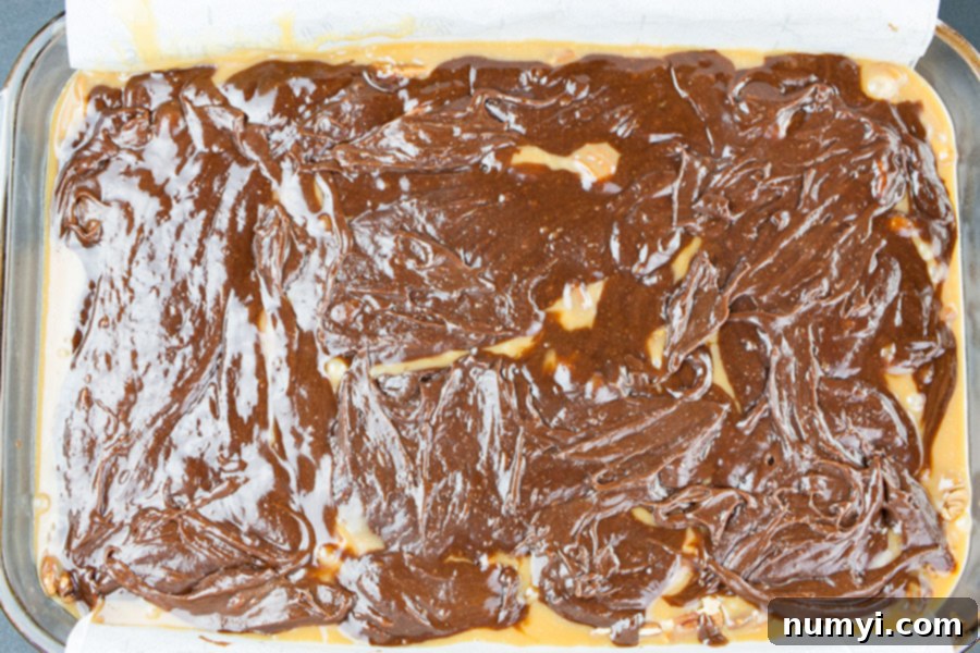 Decadent Turtle Brownies 5 The second half of rich brownie batter carefully spread over the warm caramel and pecan layer, ready for its final bake.