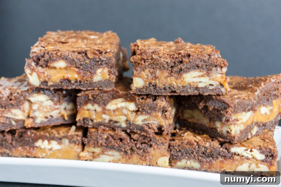 Decadent Turtle Brownies 6 Perfectly baked, rich ultimate turtle brownies, with visible layers of caramel and pecans, stacked on an elegant white platter.