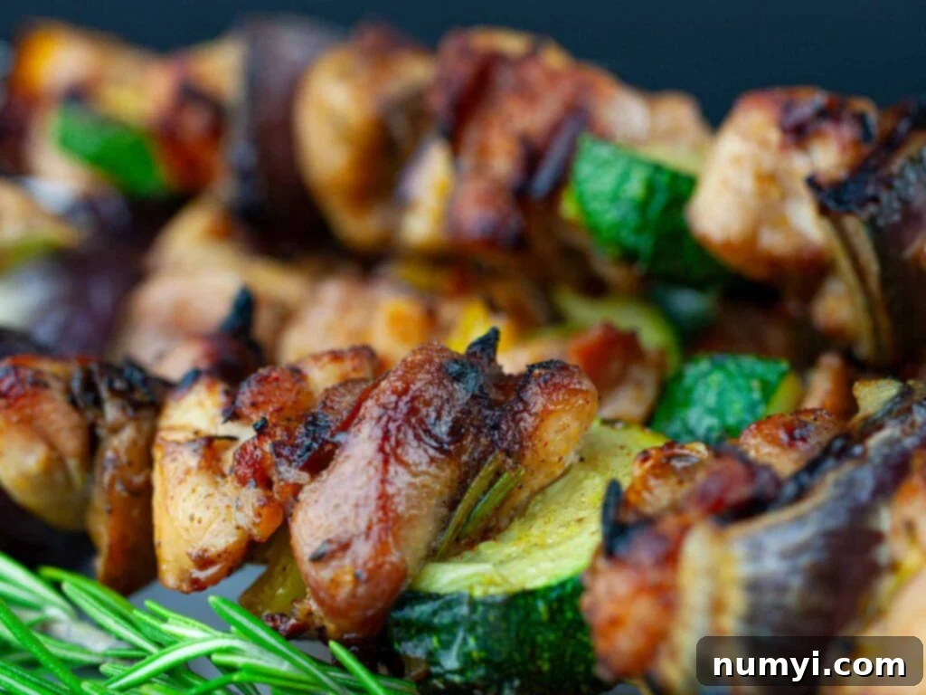 Closeup of a chicken kebab with roasted vegetables.
