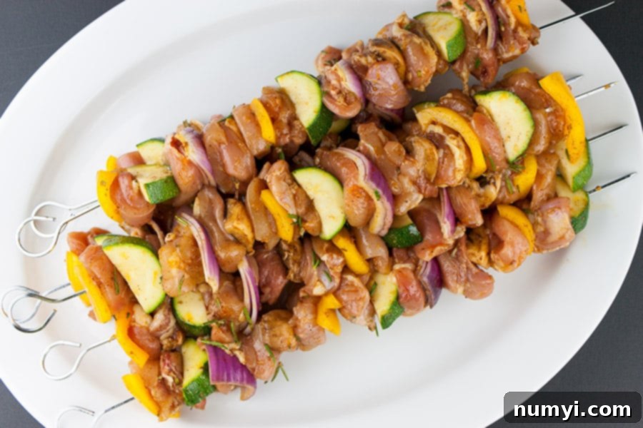 Orange Rosemary Chicken Kebabs skewered on a white platter