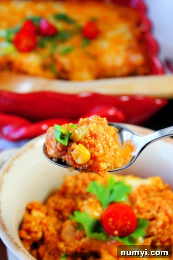 Delicious Chicken Quinoa Enchilada Bake in a baking dish, garnished with fresh cilantro and lime wedges.