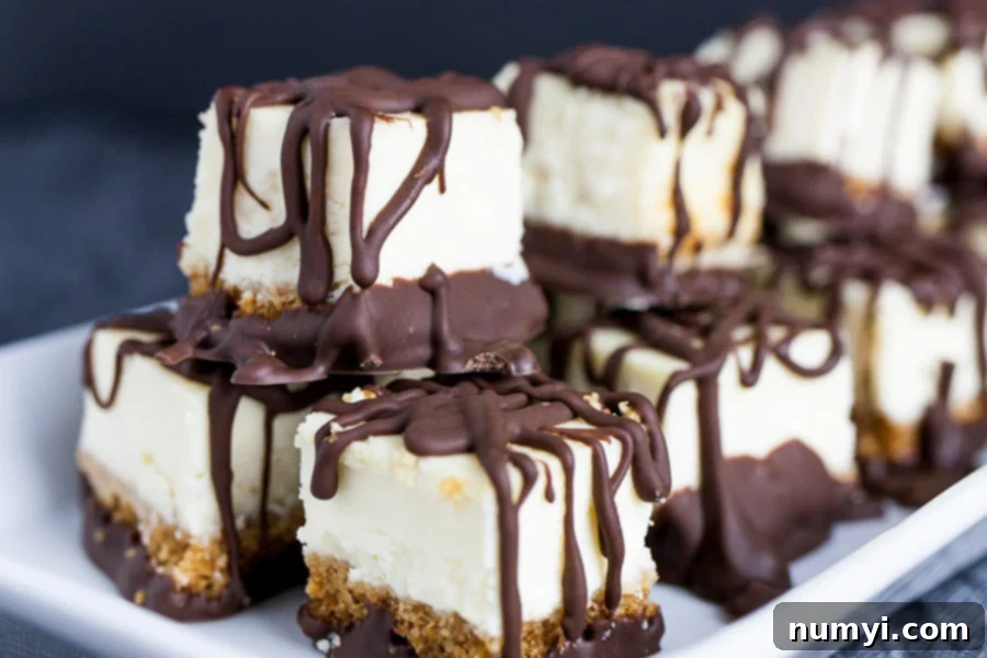 Chocolate Covered Cheesecake Bites stacked on a white plate.