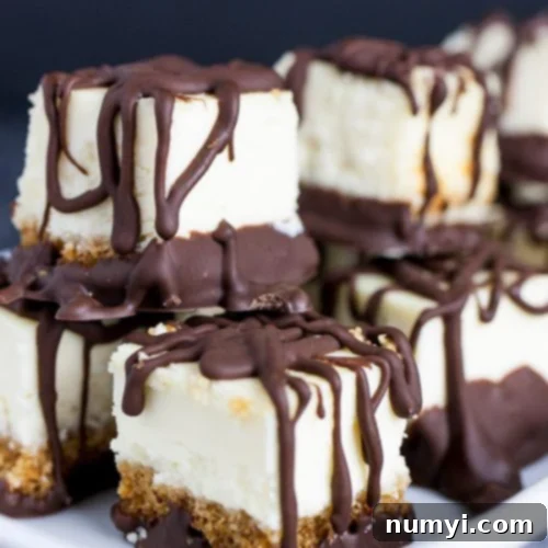 Chocolate Covered Cheesecake Bites stacked on a white plate.